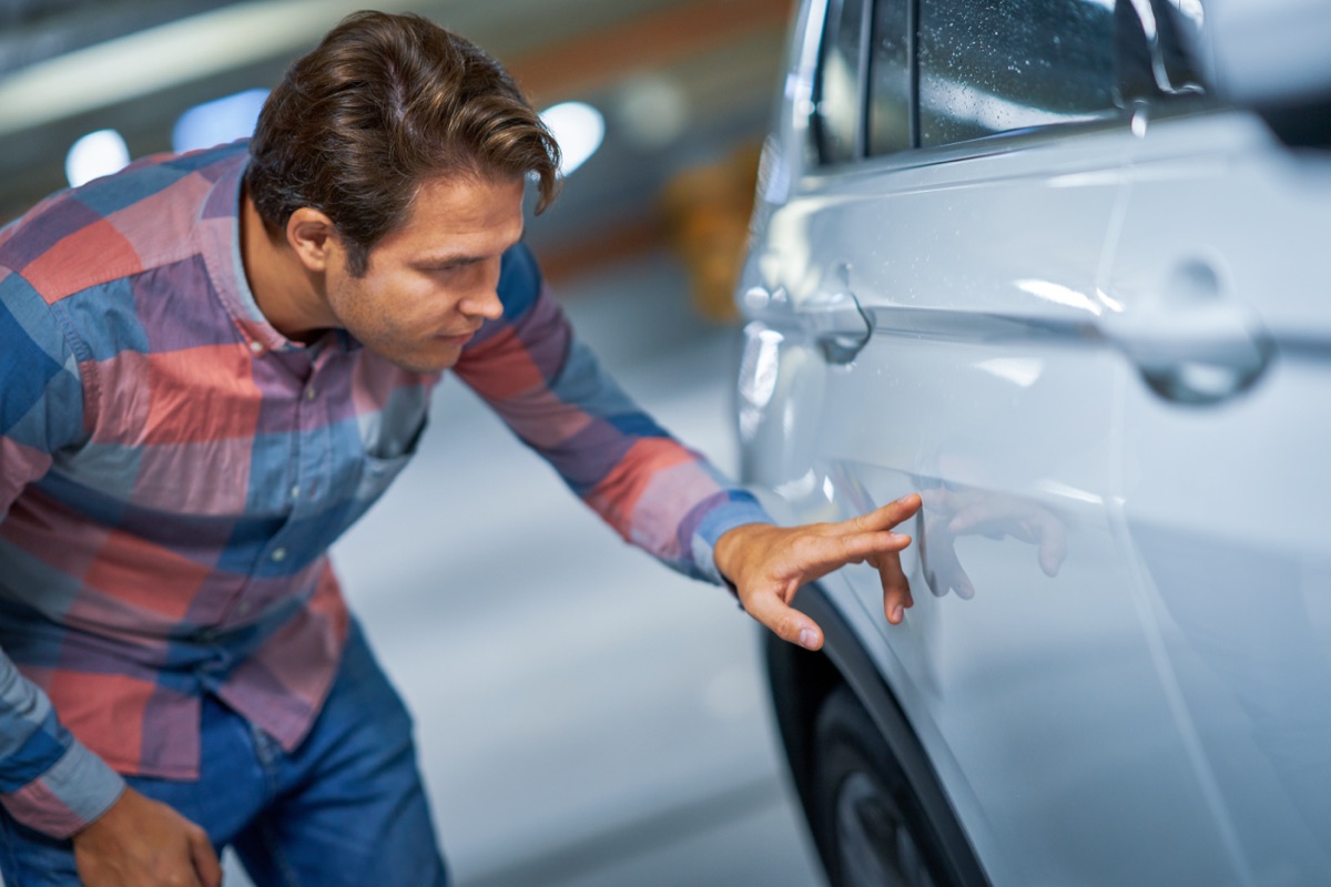 Inspecting a car door panel for damage